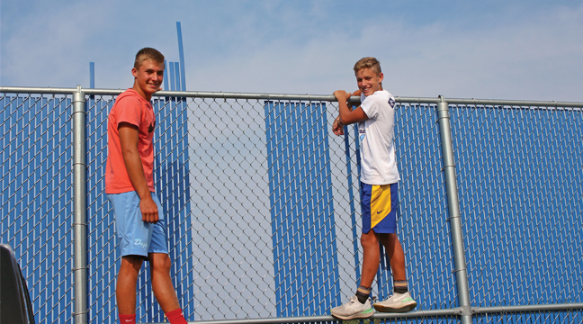 Improving the sight lines.  The Bengtson brothers, Ryan (girls tennis manager) and Zach, were hard at work removing the slats from around the tennis courts a couple weeks ago.  This will allow fans the chance to see the action better while adhering to the new MSHSL guidelines for spectators (Patriot photo by Mark Kolbinger).