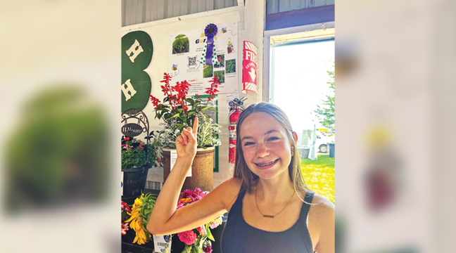 ELLA is pictured with her purple ribbon behind her in the above photo. This is Ella’s ninth year in 4-H. 