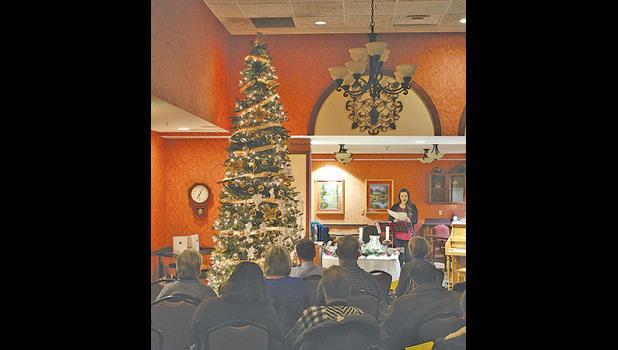 Erin Ebnet leads the guests in singing "Silent Night" after the tree-lighting at the Season of Light ceremony at St. Benedict's in Monticello Tuesday evening. (Photo by Ken Francis.)