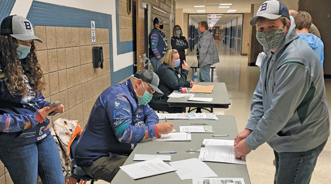 Mike Bond and daughter Olivia (L) helped out at the registration table as Greg Bowles registers his son. (Submitted Photo).