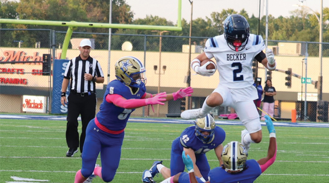Isaac Daluge hurdles three Holy Angel defenders during last Friday’s game on the road. Daluge scored one of the two Becker TDs as the Bulldogs prevaied, 14-0. (Submitted Photo from Rebecca Boecker).