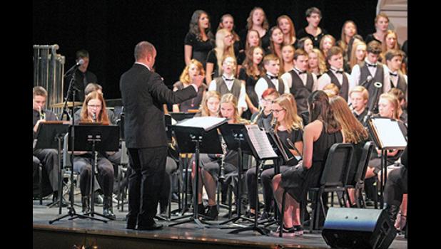 CONDUCTOR CRAIG VOGL led the students with instruments while Gretchen Bordson (not shown) directed the vocalists (background). (Photo by Bill Morgan).