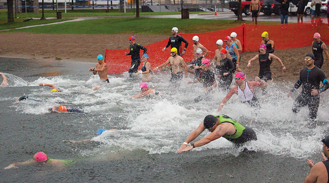 The first wave of athletes plunged into Big Lake to start the Big Lake Triathlon Saturday at Lakeside Park. Just over 200 competitors took part in the event. (Photo by Ken Francis.)