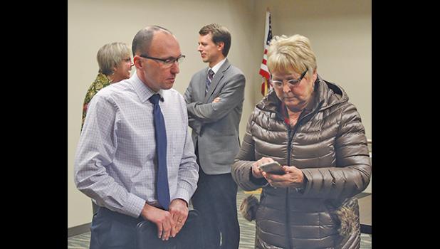 Becker City Administrator Greg Pruszinske (L) gave his contact information to Rep. Sondra Erickson at the close of Monday's meeting. In back, Commissioner Lisa Fobbe spoke with Sen. Andrew Mathews. (Photo by Ken Francis).