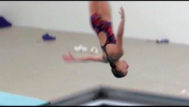 EMMA HENNESSEY twists through the air as she completes her dive during the team’s home meet Tuesday. The skill she displayed during the competition qualified her for the upcoming section meet. (Photo by Penny Leuthard)