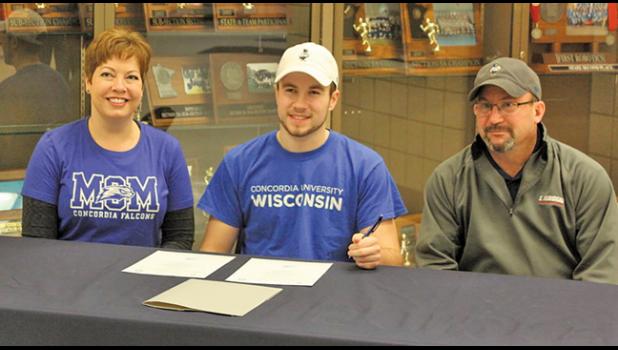 Luke Mehelich (middle) signed a letter of intent Thursday to attend Concordia University in Wisconsin on a lacrosse scholarship. Mehelich plans to study physical therapy and become an athletic trainer or physical therapist. He chose Concordia after considering four other colleges and dreams of working at Tria or the Mayo Clinic someday. Luke was joined at the signing by her parents, Dave and Cathy (above) and Luke’s sister, Kate (not pictured). (Photo by Bill Morgan)