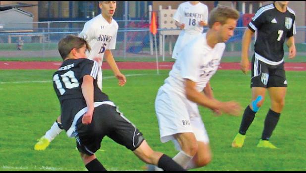 JUNIOR CARSON MAKARRALL sends the ball off for a pass in the Big Lake rivalry match Tuesday. (Photo by Penny Leuthard)