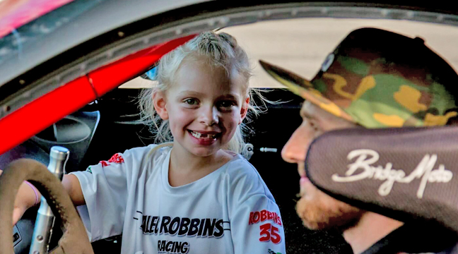 ROBBINS AND HIS DAUGHTER sit in his race car together. (Submitted photo.)