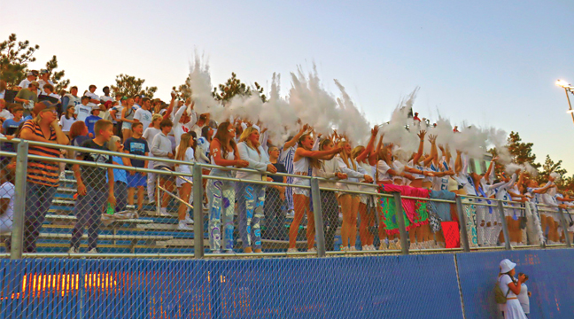 THE HOMECOMING CROWD came decked out in all styles and colors for last Friday’s game and just before kickoff a flash of powder engulfed the student section . (Photo by Rebecca Boecker).