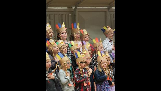 BECKER FIRST-GRADERS SHOW RESPECT for the flag by holding their hands over their hearts during the patriotic medley portion of their concert Thursday. (Photo by Penny Leuthard)