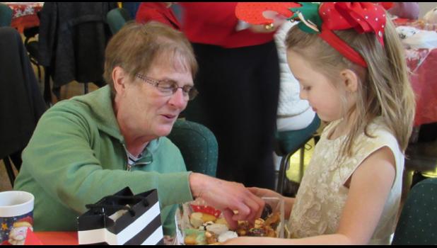 REJOICE SUNDAY SCHOOL STUDENTS dressed in their finest to serve guet Scandinavian and Christmas goodies. (Photo by Penny Leuthard) 