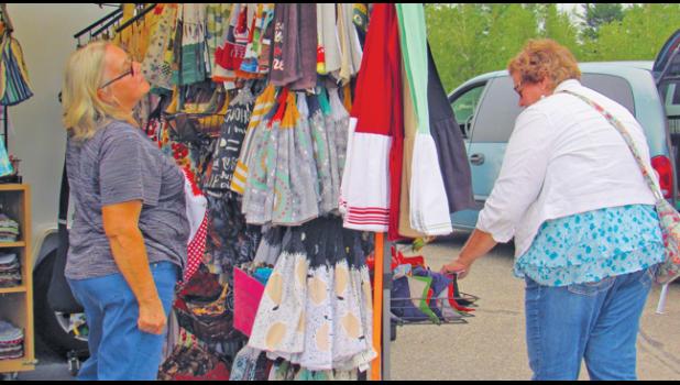 SHOPPERS LOOK OVER THE LARGE VARIETY of handmade items available for purchase at Nadine Race’s booth, Lou Lou Craft. (Photo by Penny Leuthard)
