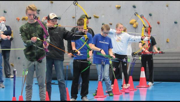 ARCHERS get a feel for the sport during last year’s archery team open house. (Photo by Penny Leuthard) 	