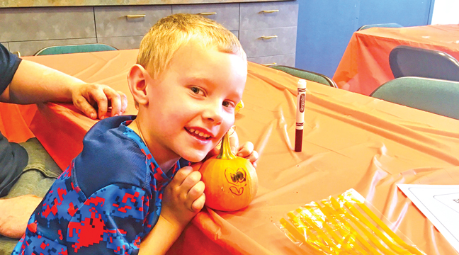 Thomas (age 6) poses with his festive creation at this year’s Sherburne Fall Fest. (Patriot Photo by Andrew Diemand.)