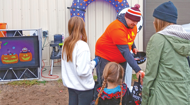 NICHOLAS THOMAS of NTE Entertainment provided music, a photo booth and candy for the little ones. Above, The Haas family of Becker stopped by for treats including mom, Shelley and sisters Aurora and Aria. (Patriot Photo by Deven Haas).