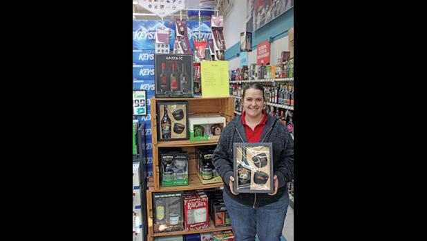 KELSEY SEELEY of Jubilee Liquor poses with some of the gift packs she has available for that perfect Christmas present. (Photo by Bill Morgan). 