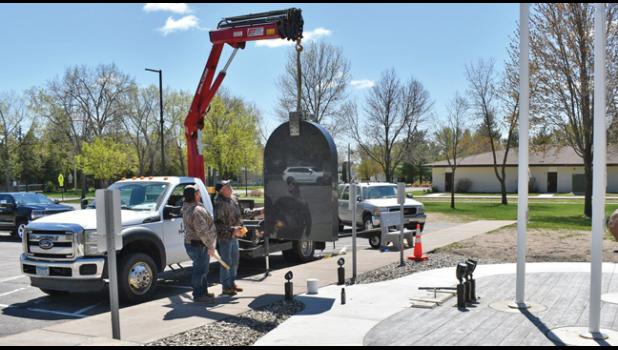 WORKERS WITH LITTLE FALLS GRANITE WORKS hoisted the monument elements to set in place at the location outside city hall. (Submitted Photos).