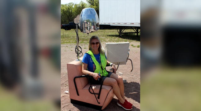 BIG LAKE TWP’S DEPUTY CLERK JAYME SWENSON tried out an old salon chair dropped off by one resident during recycle day.  (Photo by Katherine Cantin.)