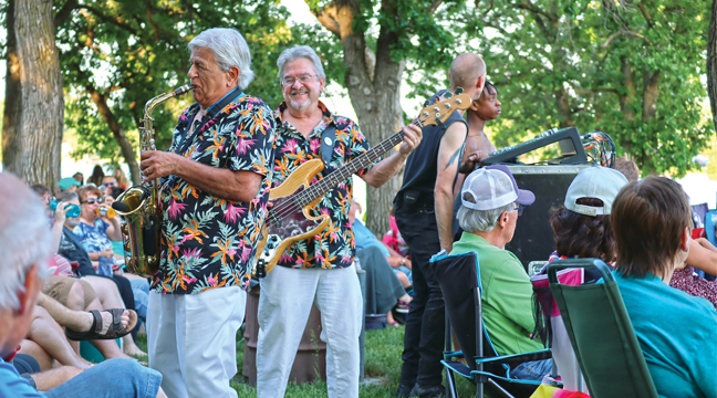 TWO MEMBERS OF THE ROCKIN’ HOLLYWOODS left the stage to mingle and jam with the crowd during last Thursday’s Music in the Park concert series at Lakeside Park in Big Lake. (Patriot Photos by Carol Hanson).