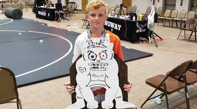 BLAYNE KUSCHEL (left photo) held up his MVP trophy for his efforts at the Grand River Rumble in Oklahoma, July 10-12. Kuschel also won MVP honors in Wisconsin last month as he wrestled for the TNT Elite Team out of Ohio in both events. (Submitted Photos).
