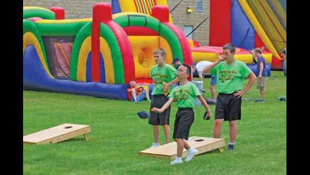 THESE TEENS in green challenged another group of youngsters in a game of bean bag toss on the grassy lawns of the Becker Community Center.