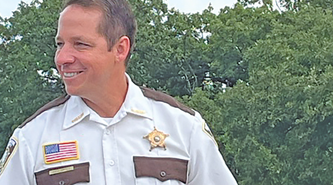 SHERBURNE COUNTY SHERIFF JOEL BROTTE handed out tootsie rolls as he greeted the throngs of people along the parade route Saturday. (Patriot Photo by Carol Hanson).