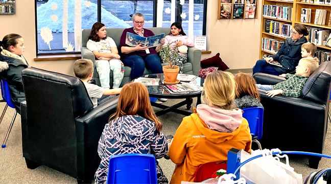 CLEARWATER LIBRARY ASSISTANT Jennifer Randall reads a winter themed story to patrons during last weekend’s story time. (Photo by Penny Leauthard.)