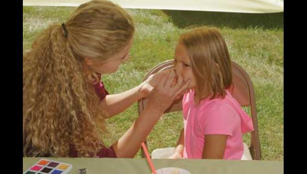 Faith is excited to be getting her face painted by Jessica.