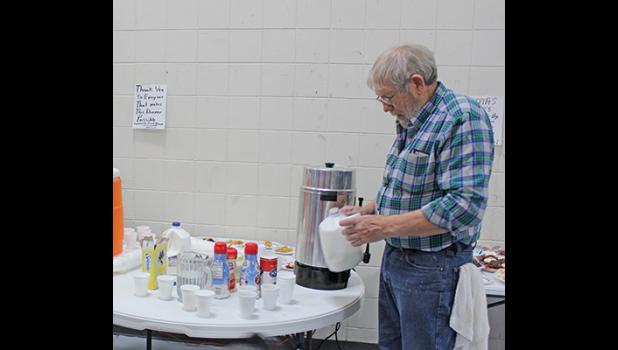 BUD STIMMLER proved he wasn’t a grumpy old man as he served coffee and milk during Tuesday’s Christmas dinner. (Photo by Bill Morgan).