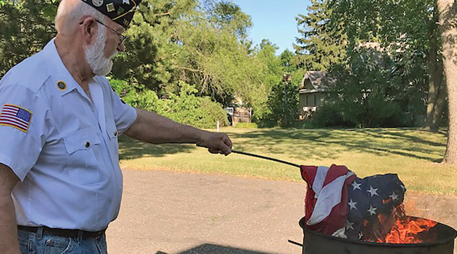 Becker American Legion Post 193 held its annual “Dignified disposal of unserviceable flags “ on Monday, June 14th in honor of Flag Day. Above, Legion Commander John Riebel burns a flag. Right First Vice Commander Mark Swanson presents an unserviceable flag to Commander Riebel for proper disposal while Legion members presented the colors and stand at attention. (Patriot photos by Carol Hanson.)