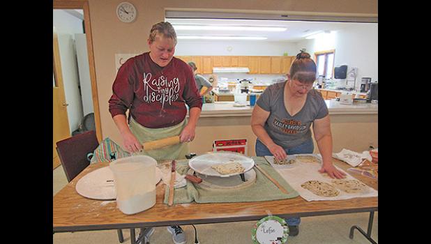MELYSSA SAKRY AND JOY GARDNER demonstrate how lefse is made for attendees at St. Luke’s Craft and Cookie Stroll. (Photo by Penny Leuthard)