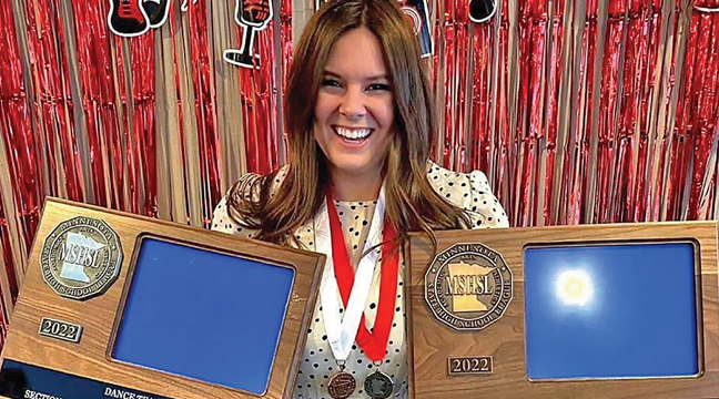 HEAD COACH NADIA FISCHER-DANZEISEN held the two section trophies her team captured at section competition last week. (Submitted Photo).