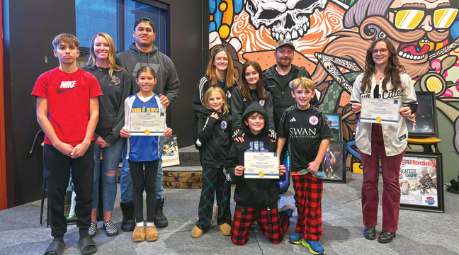 Families received their scholarships during halftime of the Vikings game.  Brittanie and her family are on the left.  (Patriot photo by Don Bellach)
