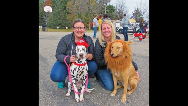 NICOLE KRANZ with her dalmatian Tootsie the firefighting dog, and Natalie Schuneman with her dog, Grunt the lion. (Photo by Penny Leuthard)