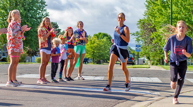 Christa Hartkopf, Clear Lake, turns the corner near a cheering squad decked out in Hawaiian gear. (Submitted photo.)