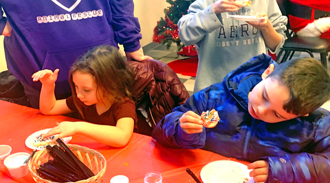  NOAH, PAIGE, AND JADYN enjoy their freshly decorated cookies. They were at the Kids Christmas Party with their Aunt Sarah. (Photo by Penny Leuthard.)