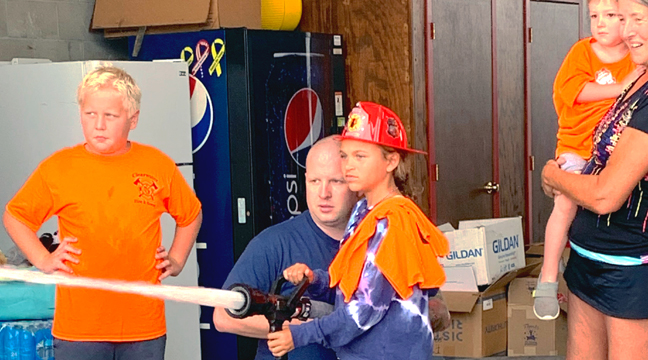 THE CHANCE TO MAN A FIREHOSE (right) was a popular activity at the Clearwater Fire Dept.’s open house. (Photo by Penny Leuthard.)