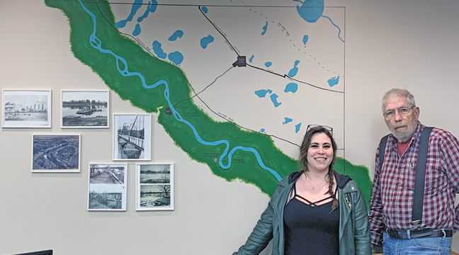 REANNA LEUTHARD AND BUD STIMMLER with the completed Clear Lake Twp. map now adorning the new township hall. (Photo by Penny Leuthard)