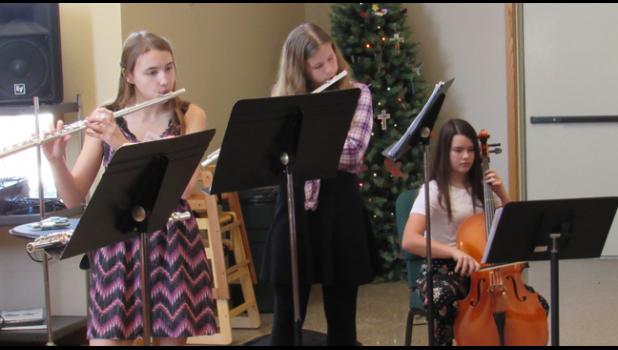 OLDER YOUTH FROM REJOICE, including Macie Groth, Preston Maile and Brookelyn Lindberg, entertain European Christmas guest with holiday music dressed in their finest to serve guet Scandinavian and Christmas goodies. (Photo by Penny Leuthard) 