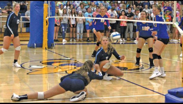 BREEIN WAYTASHEK (front) and Tina Gruber (M) gave their all for the ball at the net while Jillian Olson (L) gets ready to help. (Photo by Gloria Vander Brake).