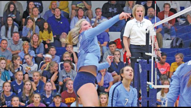 JILLIAN OLSON skyed above the net to send this shot back in an earlier match at home this year. Allie Hill (#7) looked on. (Photo by Bill Morgan).