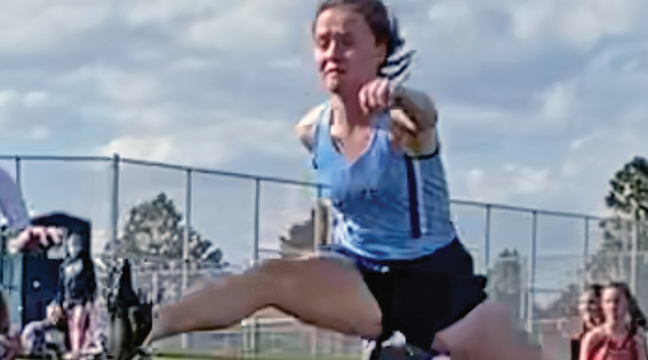 REGAN HAUSMANN soared over the hurdle in her race Thursday. (Submitted Photo)