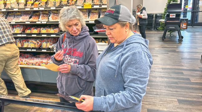 McDonald’s Meats Co-owner Jennifer Dierkes (in hat) helps a customer with questions about Turkey brines. (Patriot photo by Don Bellach)