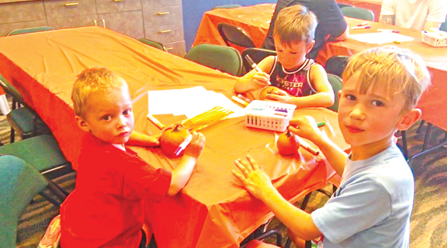 THESE THREE BOYS, (L to R): Wesley (age 4), Maddox (age 6), and Cooper (age 5) decorated pumpkins at this year’s Sherburne Fall Fest. (Patriot Photo by Andrew Diemand.)