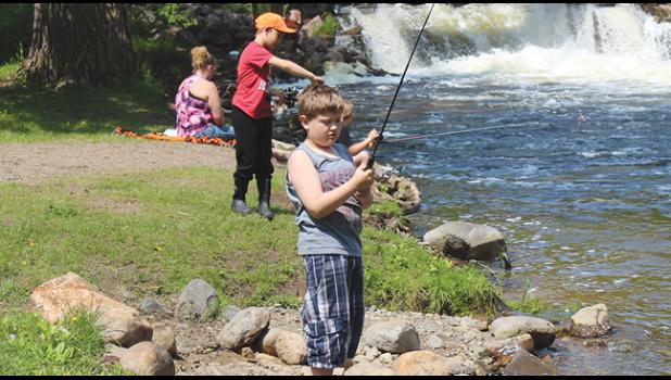  Logan Smith (foreground) and Aleck Quamme (orange hat) try their hand at catching fish in the Clearwater River during Saturday's S.A.L. fishing event at Riverside Park. (Photos by Ken Francis.)