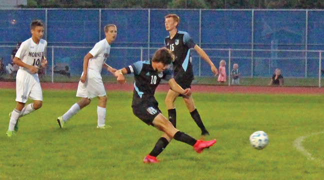 Senior Captain Carson Makarrall connects on a kick for the Becker Bulldogs boys soccer team. (Patriot photo by Mark Kolbinger).