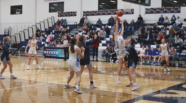 Big Lake’s Emily Steen goes up for a rebound as she is being guarded by Becker’s Maren Westin.  Steen led the Hornets with 12 points, 10 rebounds and 4 steals. (Photo by Mark Kolbinger.)
