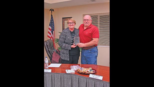 MAYOR TIM GOENNER presents a plaque of appreciation to out-going council member Sandy Paige. (Photo by Penny Leuthard)