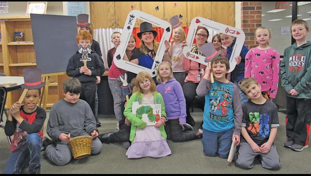 Clearview second graders, along with their teacher Ms. Gerdes and Media Paraprofessional Rachael Kimmerle, pose for a picture at the magical photo station, one of the fun ways the library has been decorated to celebrate this year’s One District One Book, The Vanishing Coin. (Photo by Penny Leuthard)
