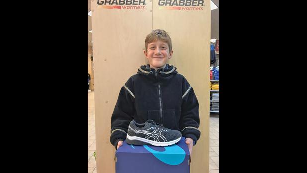 FOURTH-GRADER IAN LANGBEHN proudly shows off the Adidas shoes he chose as his prize for running the most morning miles in November. (Submitted photo)